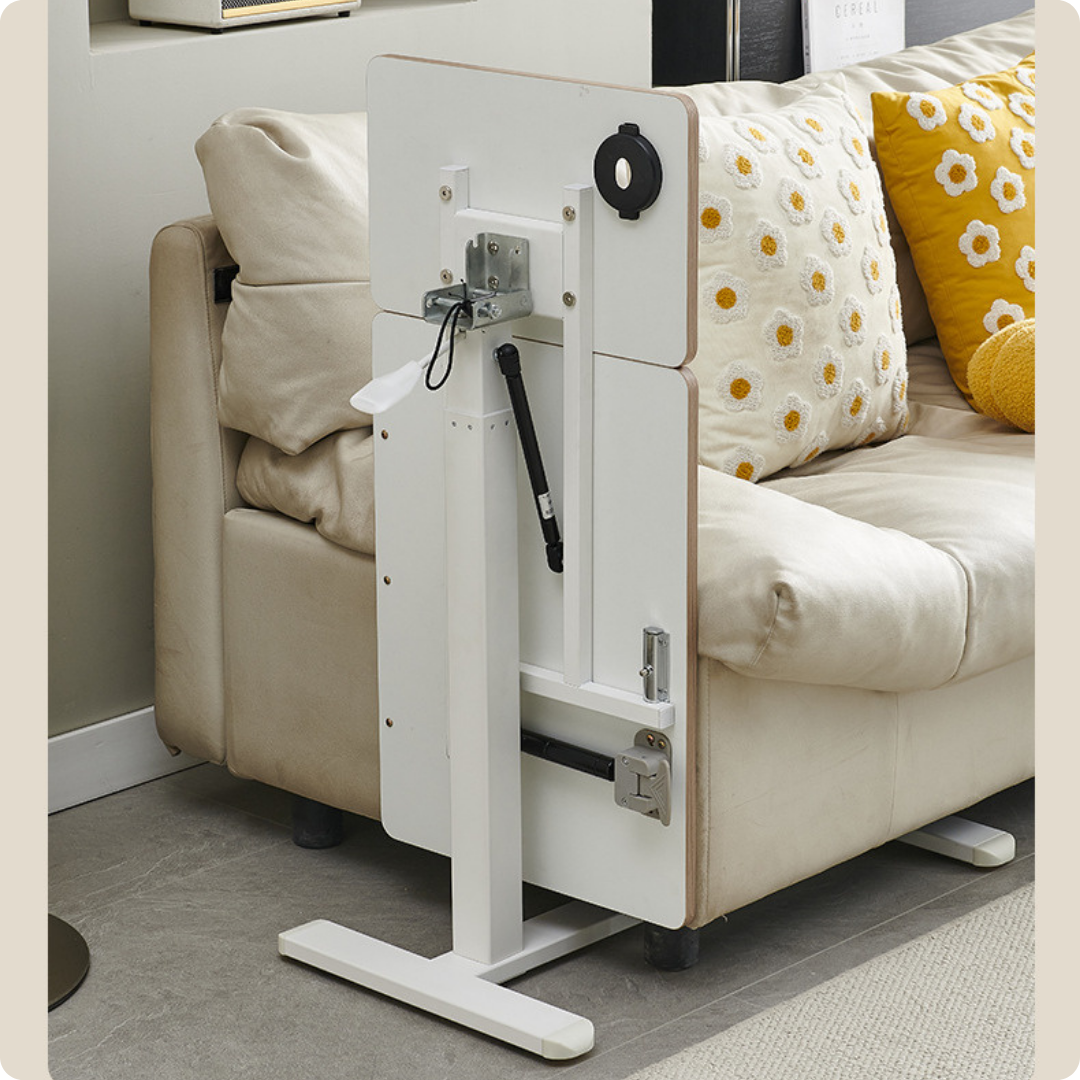 Bàn nâng hạ cạnh giường ngủ tại nhà, cạnh ghế sofa, mặt bàn có khả năng xếp gọn khi không dùng.